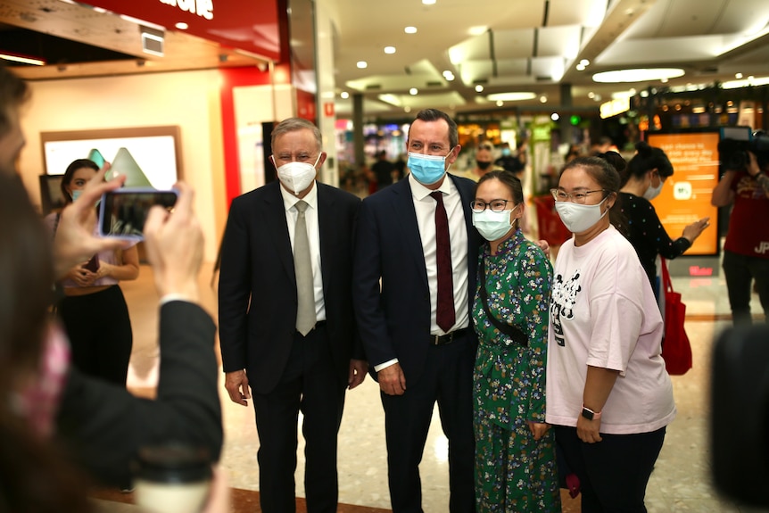 Mark McGowan and Anthony Albanese pose for selfies with two women in a shopping centre