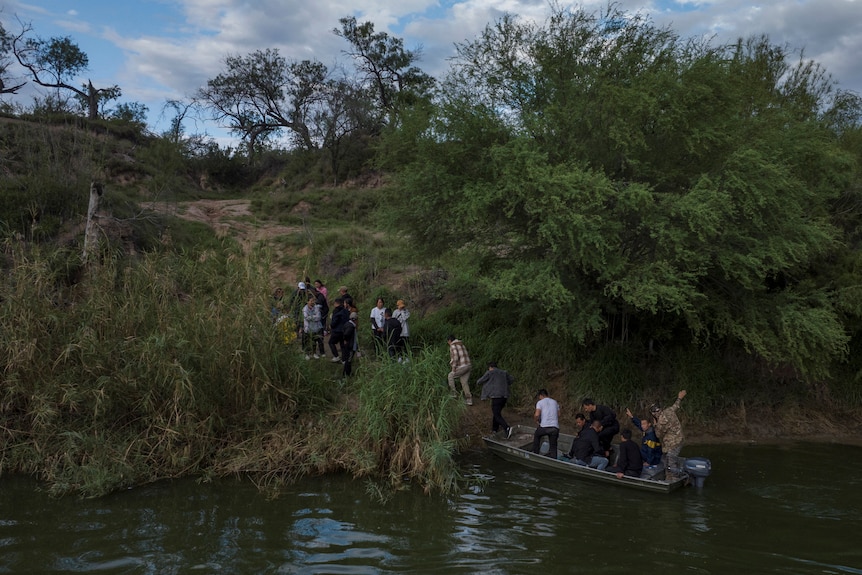 A group of Chinese nationals leaving a boat in the Rio Grande river