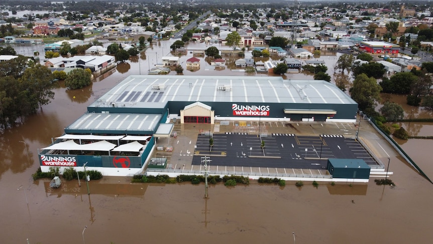 A bunnings carpark full of muddy brown flood water. 