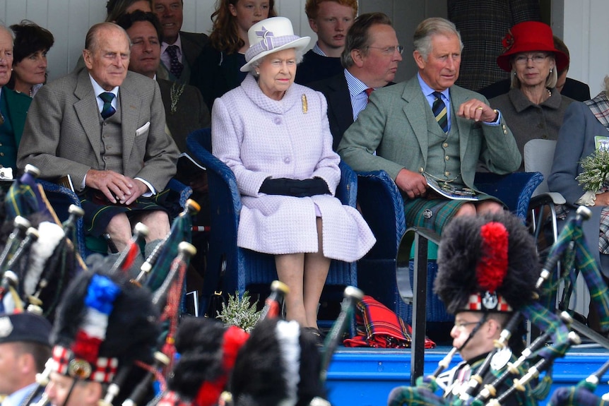 Prince Philip, Queen Elizabeth and Prince Charles watching pipe band in Scotland