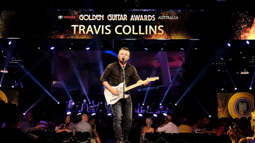 Travis Collins performs live on stage.