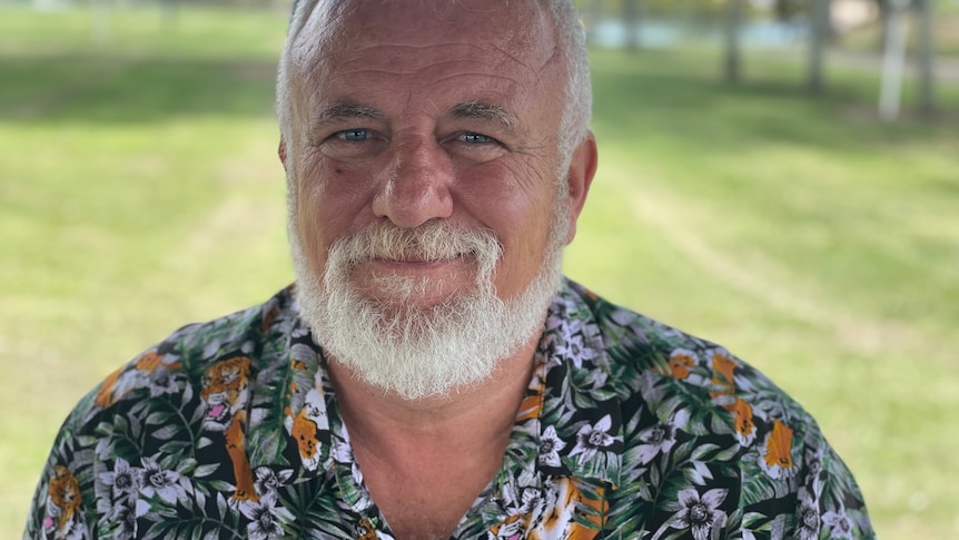 Close up portrait of a man with a white beard and a colourful shirt 