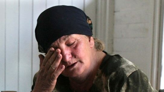 A South Ossetian woman cries as a girl sleeps on her lap