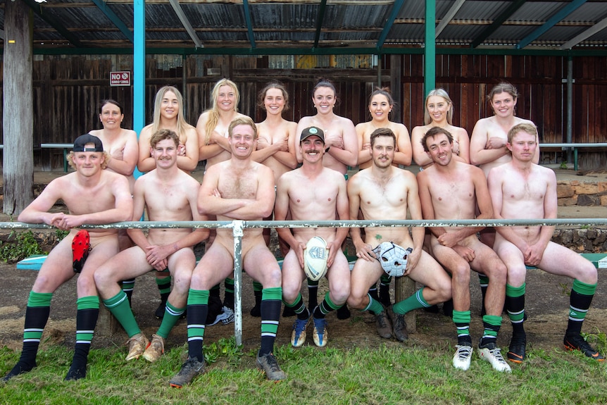 A sports team of men and women wearing nothing except football socks and balls over their bits.