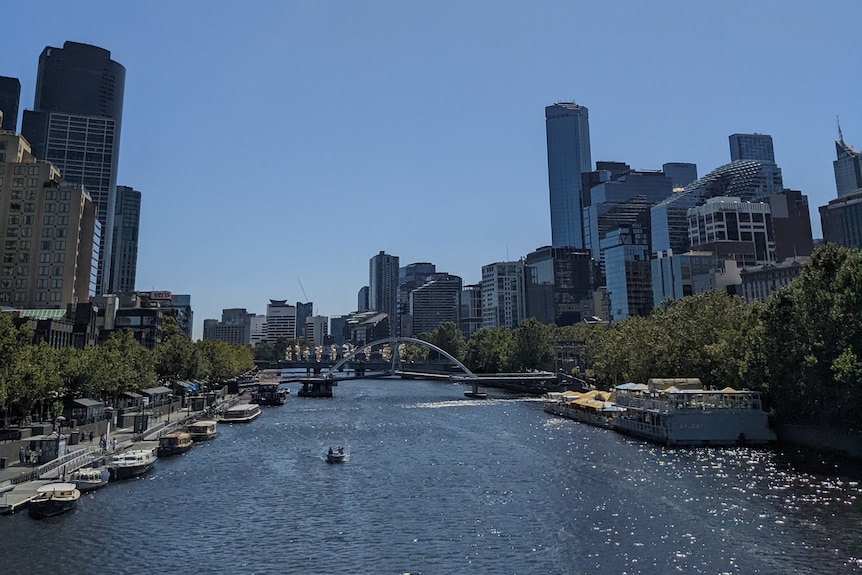 Tall buildings in Southbank and Melbourne CBD either side of the Yarra River on a sunny day.