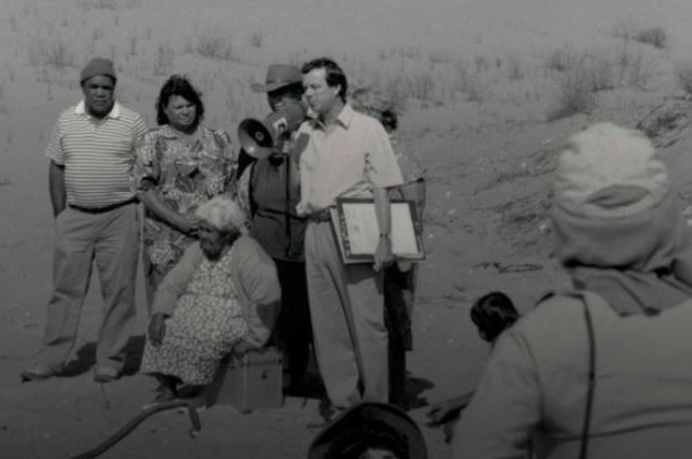 A black and white photo of Mike Rann with a group of people including Archie Barton.