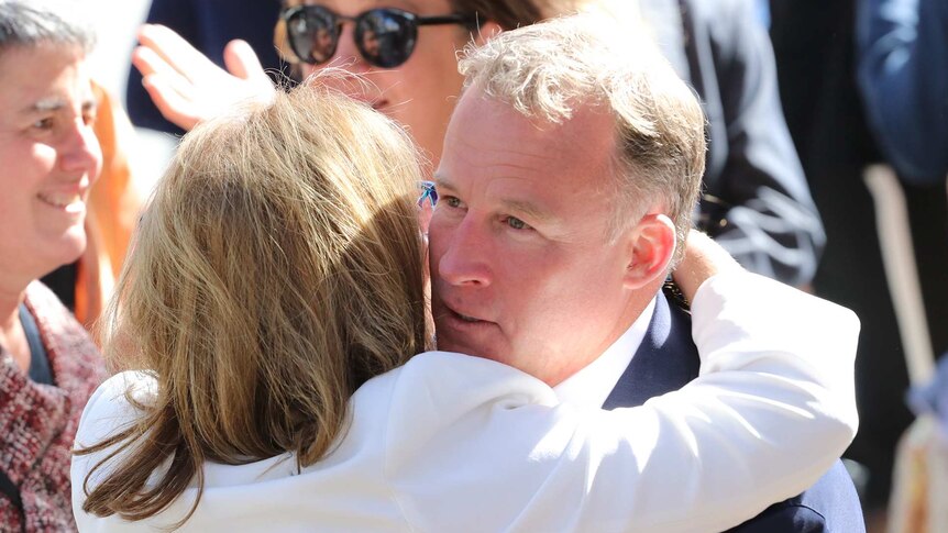 Premier Will Hodgman embraces a mourner at funeral of Vanessa Goodwin, St David's Cathedral, Hobart.