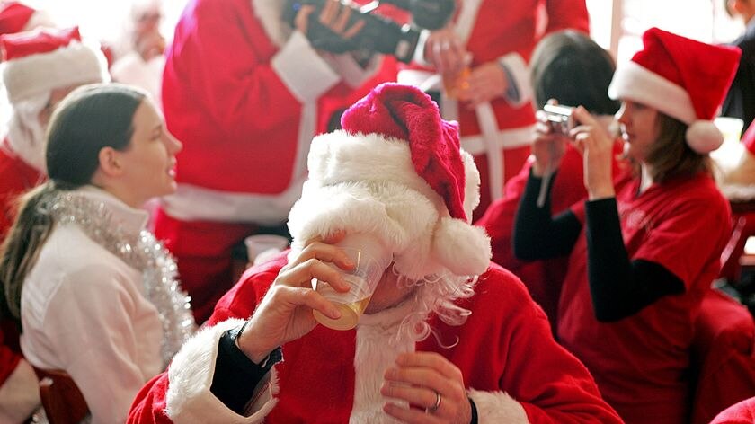 A Santa Claus drinks beer