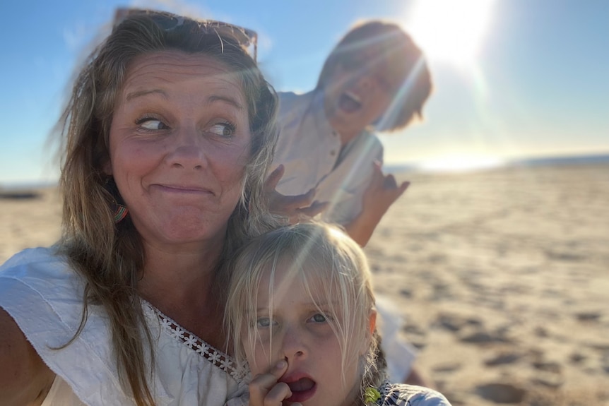 Victoria Vanstone at the beach with her son and daughter pulling faces. Being a present parent has been a goal of her sobriety.