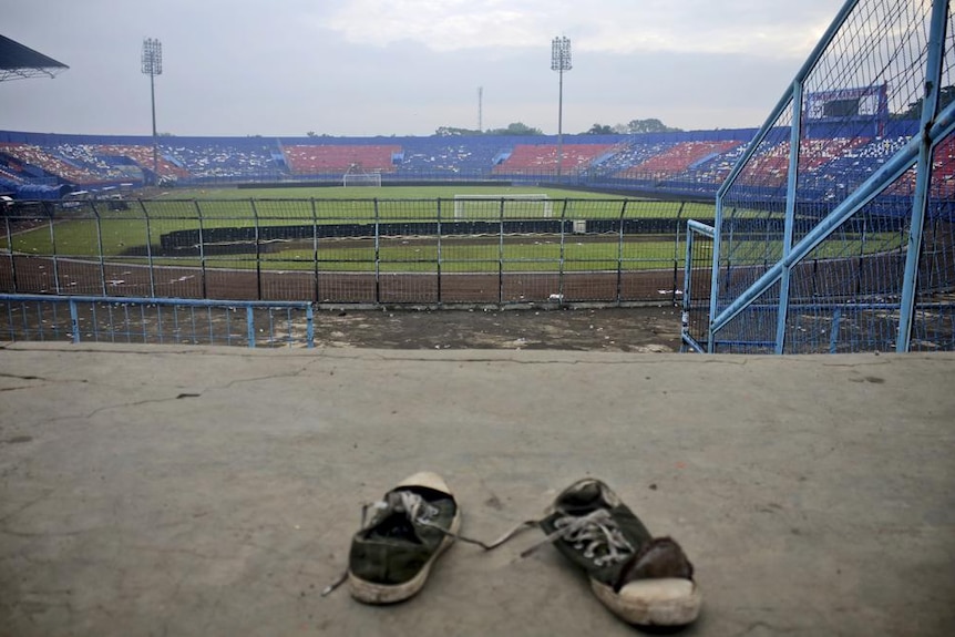 A pair of sneakers sit trampled in the stands of Kanjuruhan Stadium.
