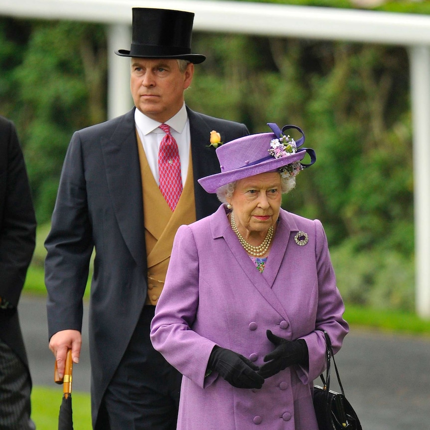 Prince Andrew, wearing a black top hat, stands behind the Queen, wearing a purple hat, at a horse racing track.