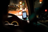 An Uber driver navigating using a mobile phone
