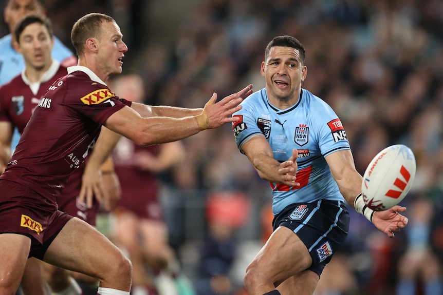 Cody Walker passes the ball in front of Daly Cherry-Evans