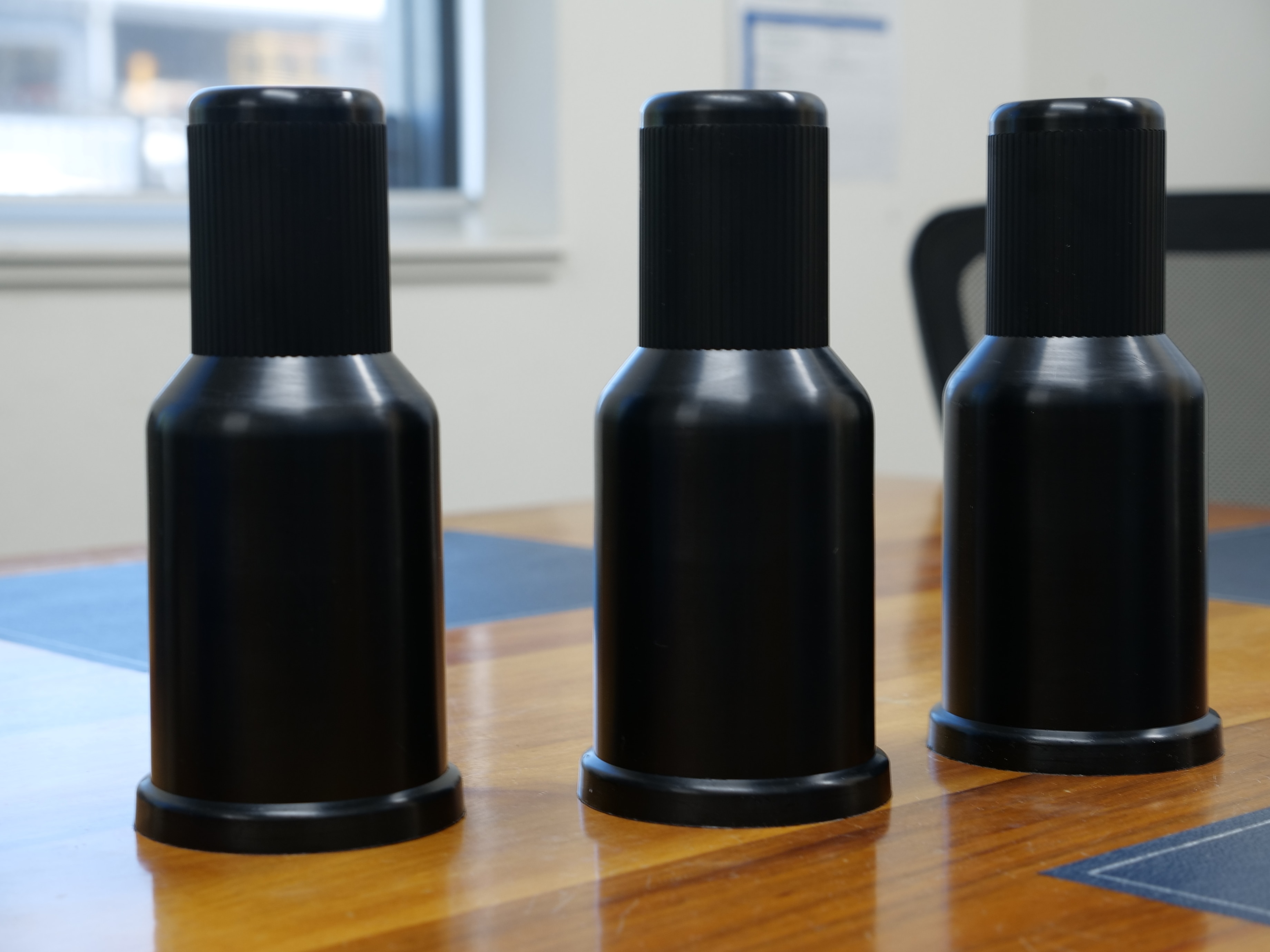 Three black bolts on a table.