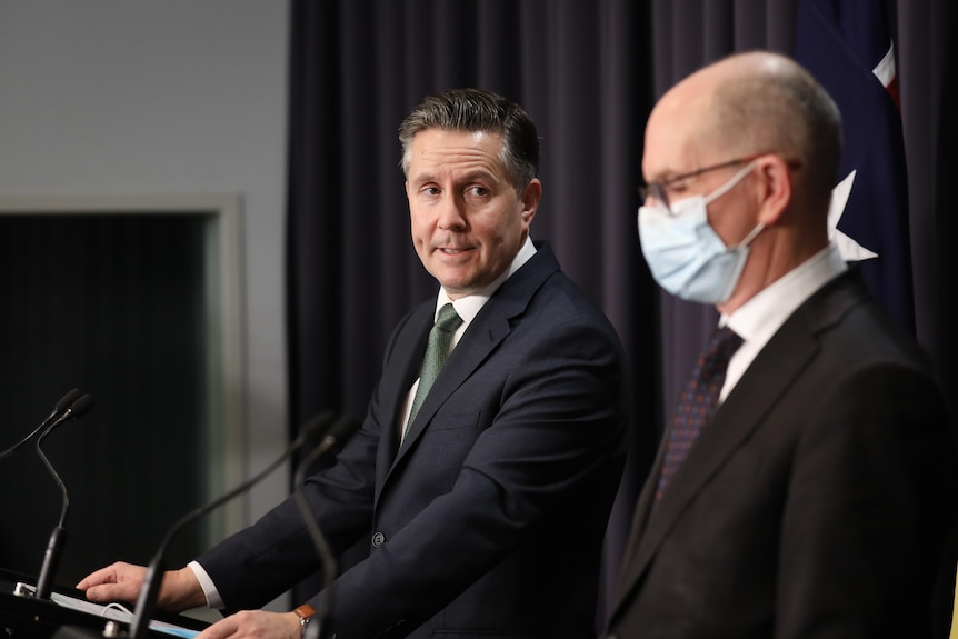 Mark Butler looks at Paul Kelly during a press conference 