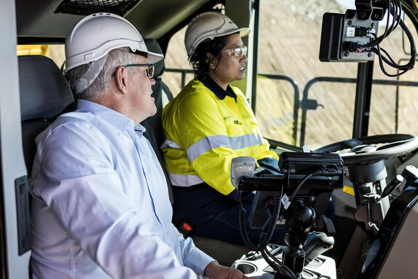 El primer ministro Scott Morrison hablando con una camionera en la cabina de un camión minero. 