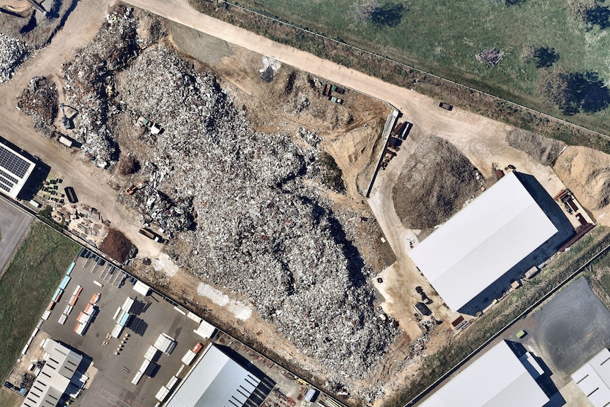 A satellite view of warehouses and a large pile of scrap metal.