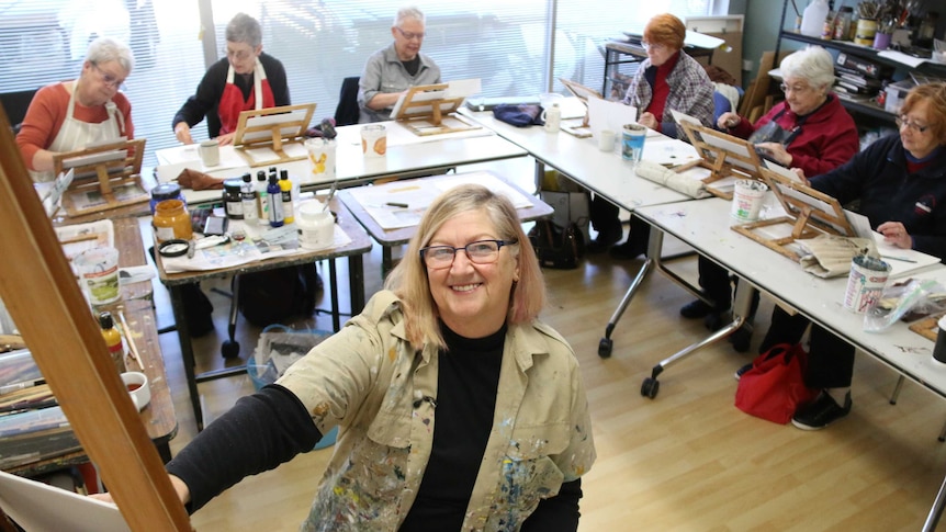 Margaret Hadfield at her art class, surrounded by students.