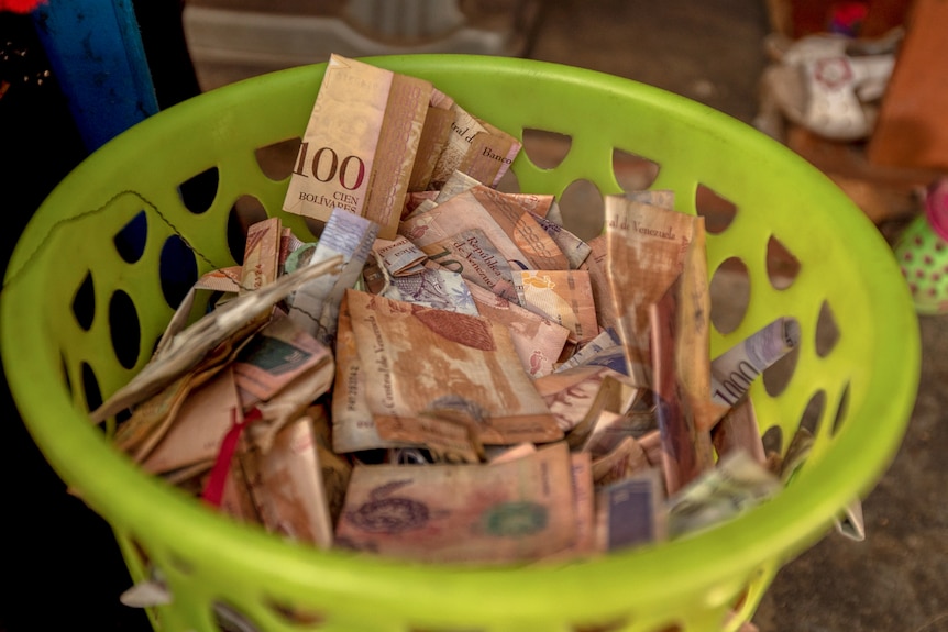 A bright green bucket of Venezuelan bank notes