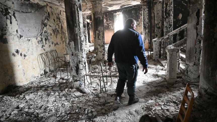A man walks through a destroyed theatre in Mariupol.
