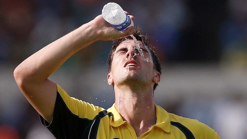 Australia's Pat Cummins pours water on his face during the second ODI against India in Kolkata.