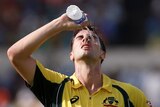 Australia's Pat Cummins pours water on his face during the second ODI against India in Kolkata.