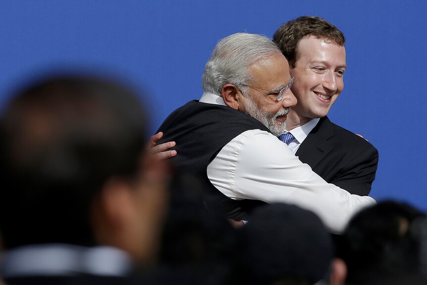 Indian PM Modi embraces Facebook CEO Mark Zuckerberg on stage at a talk, September 27, 2015.