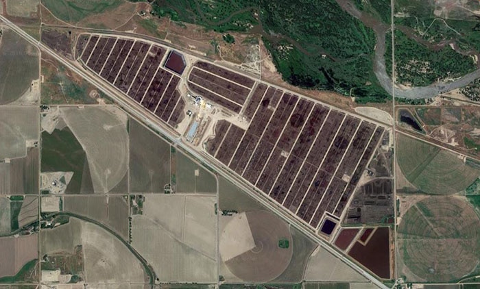 A satellite image shows the brown yards where cattle are farmed for beef.