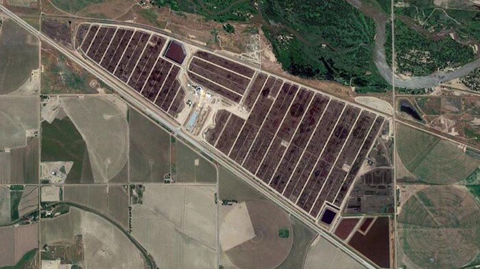 A satellite image shows the brown yards where cattle are farmed for beef.