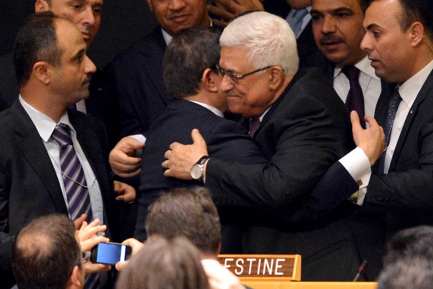 Mahmoud Abbas gets a hug after the UN vote to upgrade the status of the Palestinian Authority.