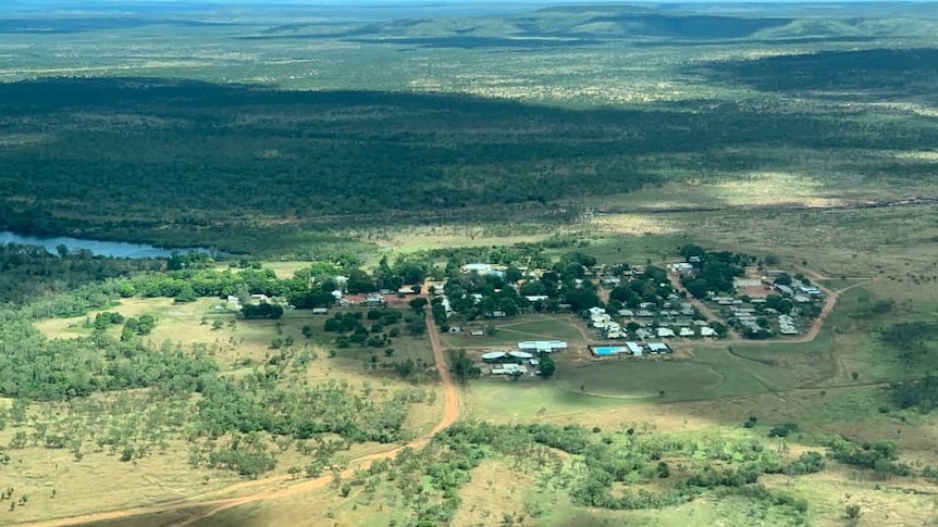 an aerial photo of a small town surrounded by green bushland