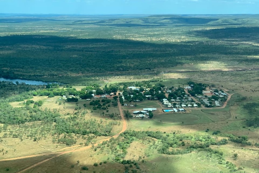 an aerial view of a small town surrounded by green bushland