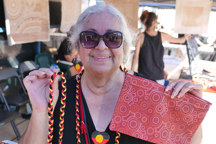 Indigenous woman holding up arts and crafts