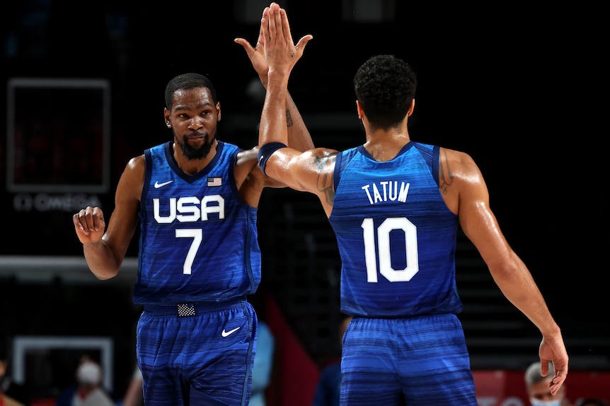 Kevin Durant and Jayson Tatum of Team USA basketball exchange a high five.