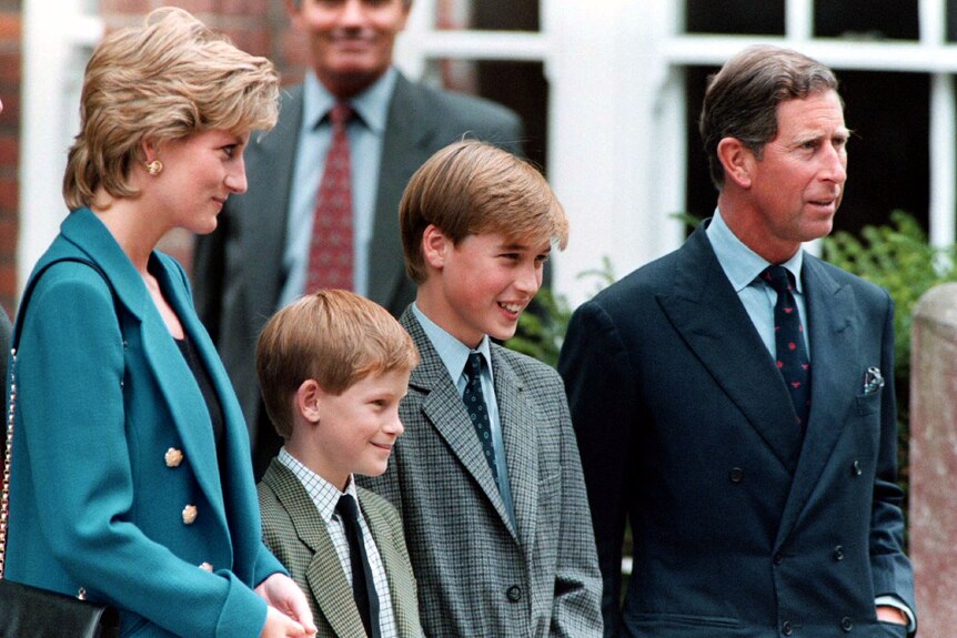 Prince Charles in a suit and spotty tie, Princess Diana in teal blazer, young Prince Harry and teenaged Prince William in suits