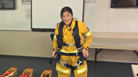 Woman in firefighting gear standing in a room
