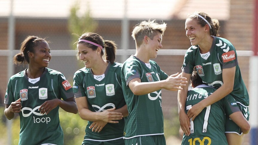 To the victor ... Nicole Sykes (R) is congratulated by team-mates after scoring the winning goal
