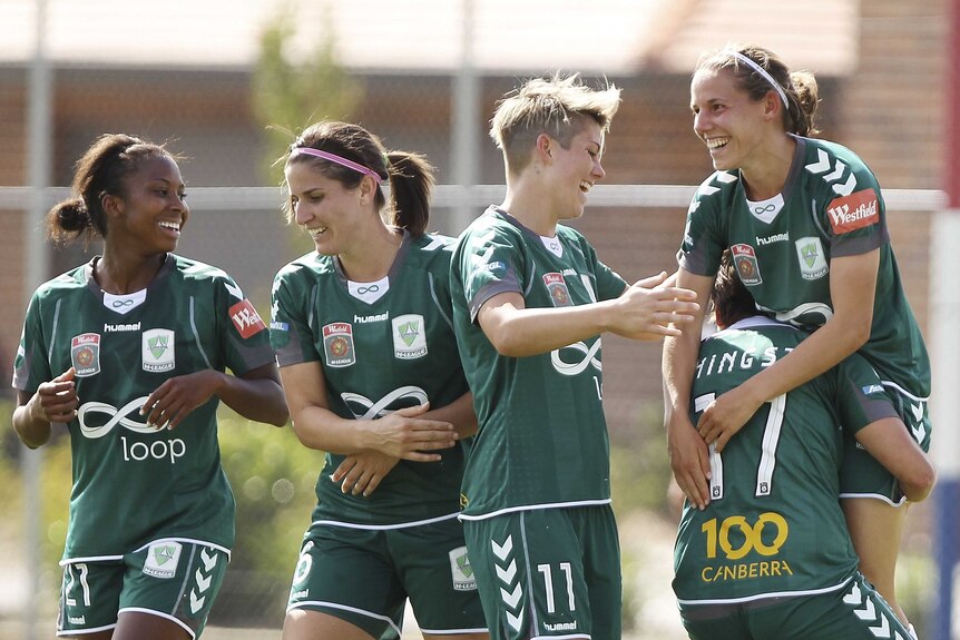 To the victor ... Nicole Sykes (R) is congratulated by team-mates after scoring the winning goal