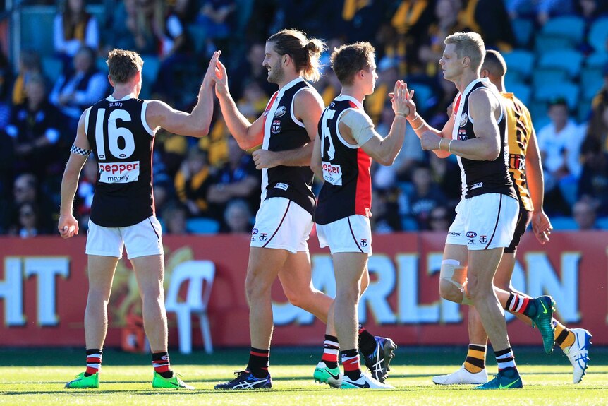 Josh Bruce (2L) is congratulated by St Kilda team-mates after his goal against Hawthorn.