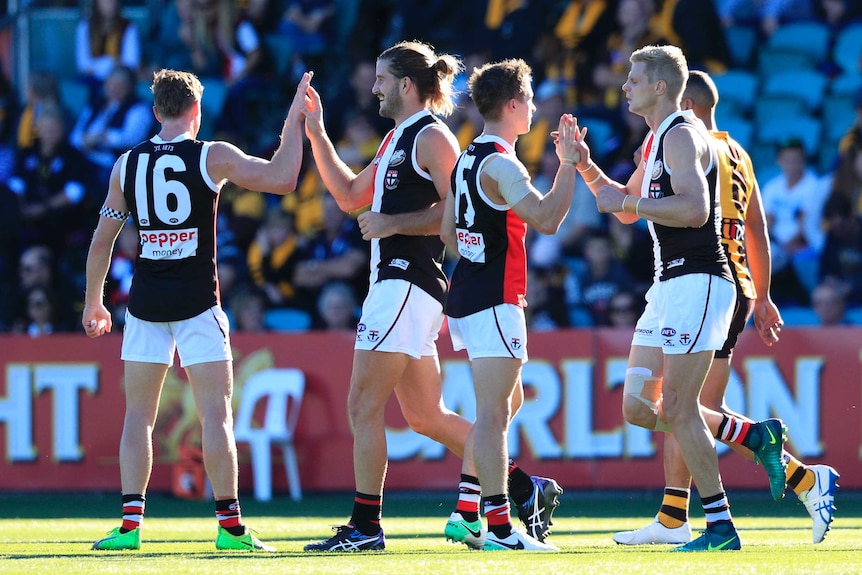 Josh Bruce (2L) is congratulated by St Kilda team-mates after his goal against Hawthorn.