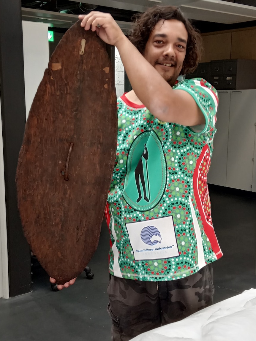 Rodney Kelly smiles while holding the shield.