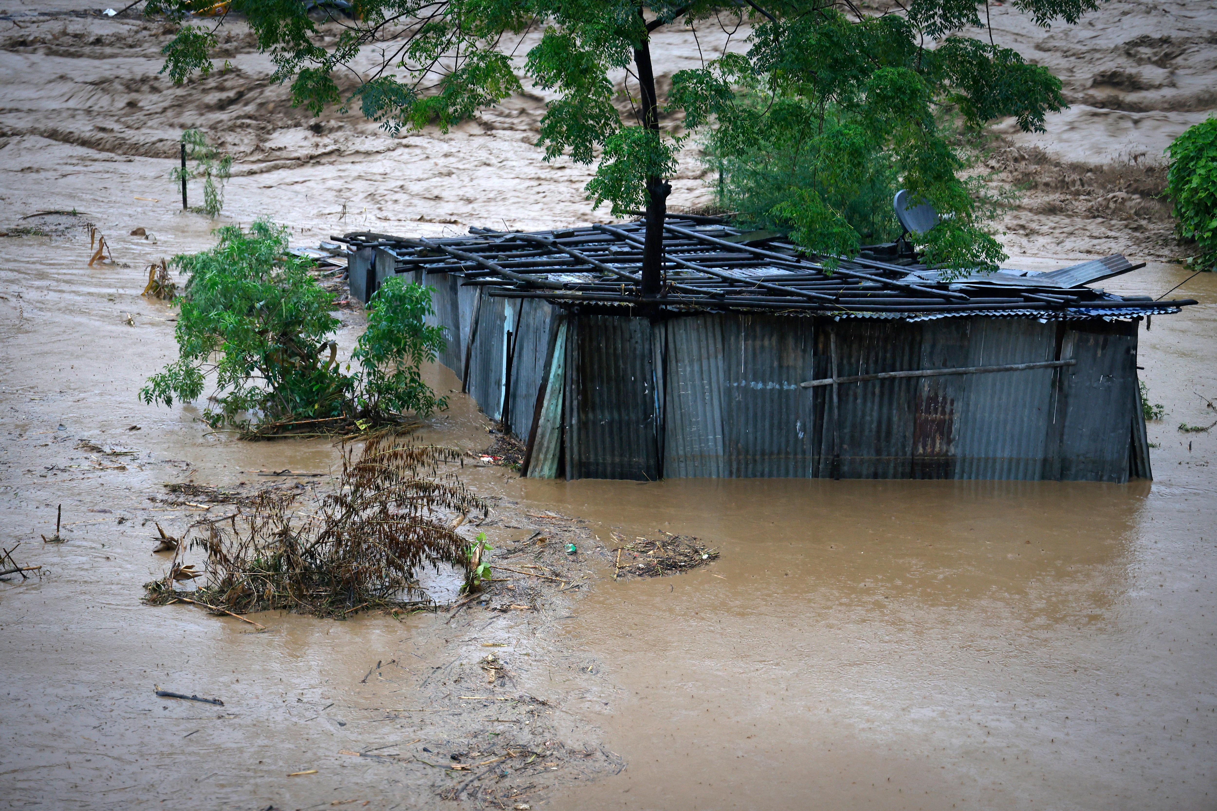 A tin shed partially submerged in floodwaters