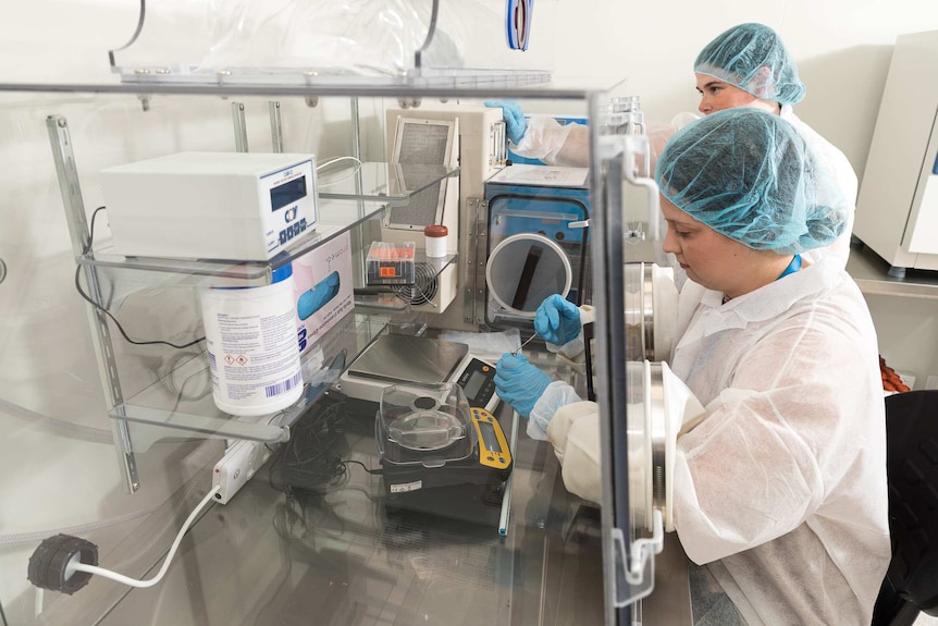 Two people in a lab processing stools.