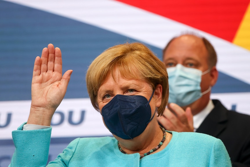 German Chancellor Angela Merkel wearing a facemask and light blue jacket.