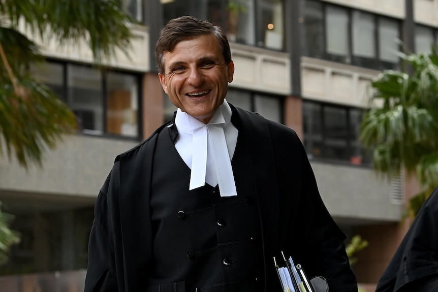 a man holding files and smiling