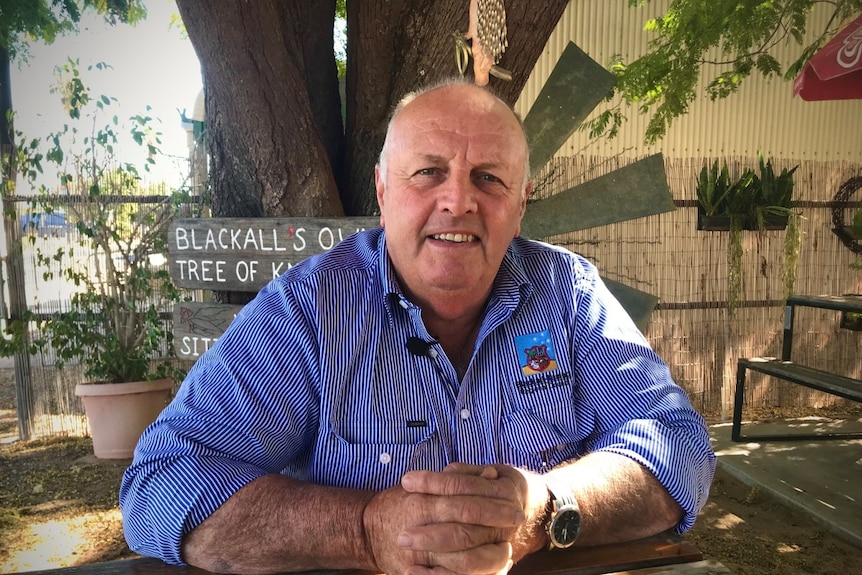 Blackall mayor Andrew Martin is sitting at an outdoor table at a cafe.