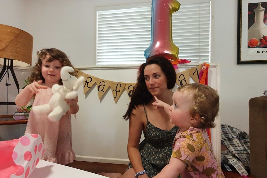 Two little girls and a mum having a birthday party.