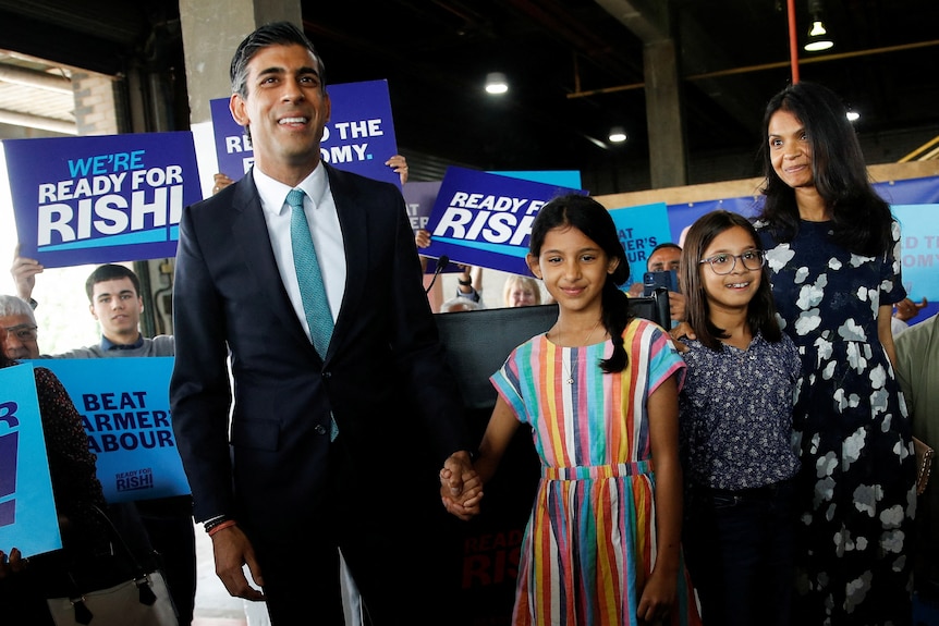 Rishi Sunak walks hand-in-hand with his two young daughters and wife Akshata.