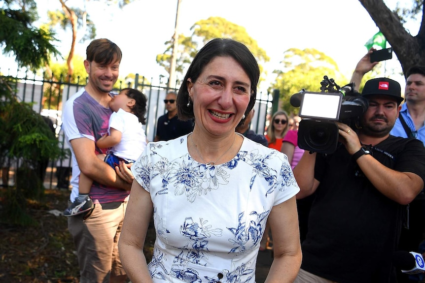 gladys in white dress in crowd at school, smiling