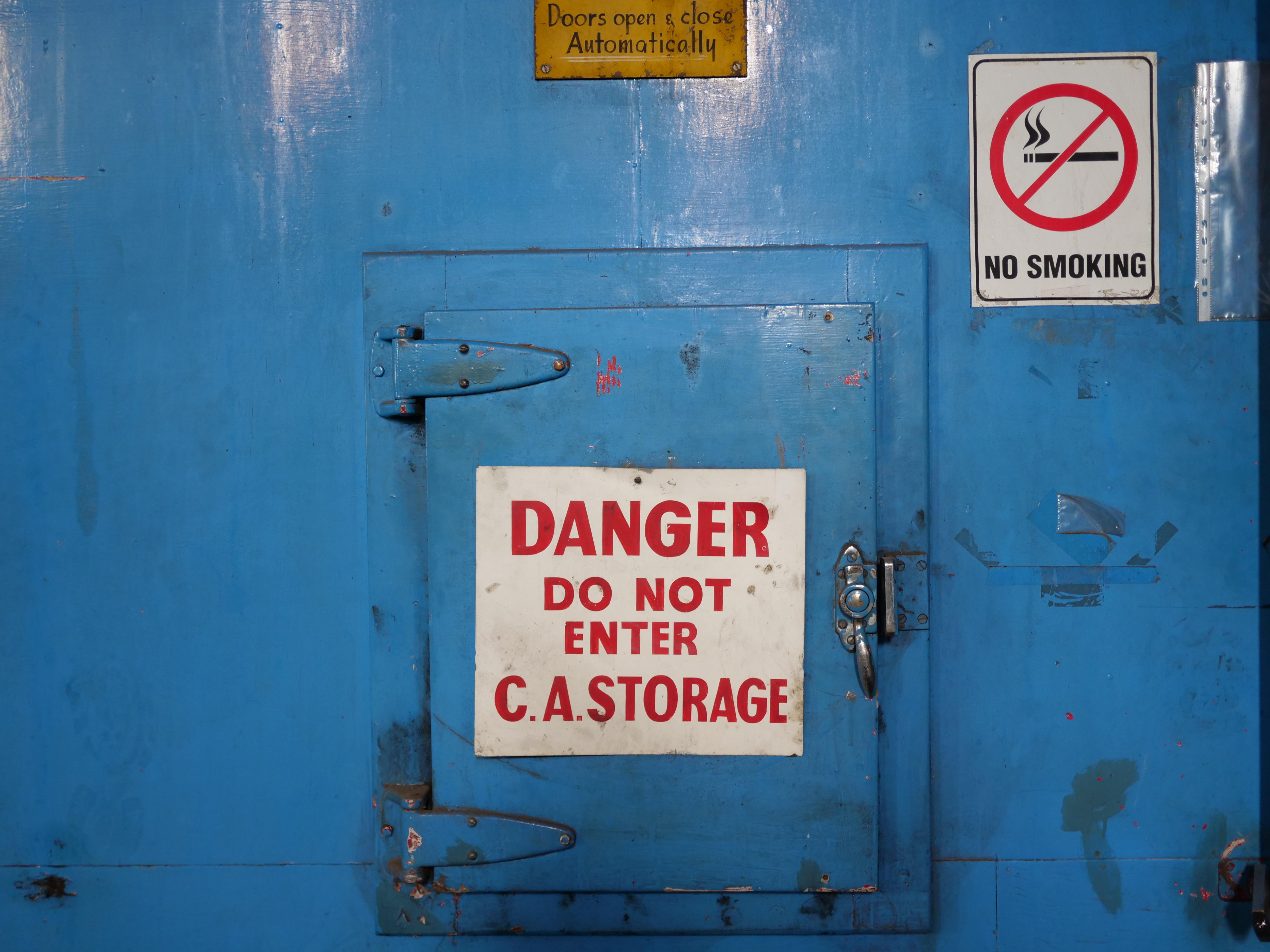 Fotos de una puerta con un cartel grande que dice “ "PELIGRO NO ENTRAR. almacenamiento de CA"